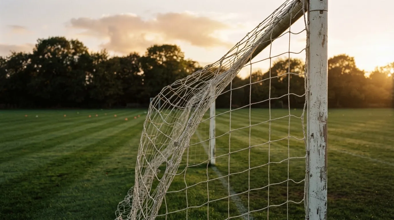 Ein Fussballtor mit locker hängendem Netz auf einem Trainingsplatz, das sich leicht im Wind bewegt.